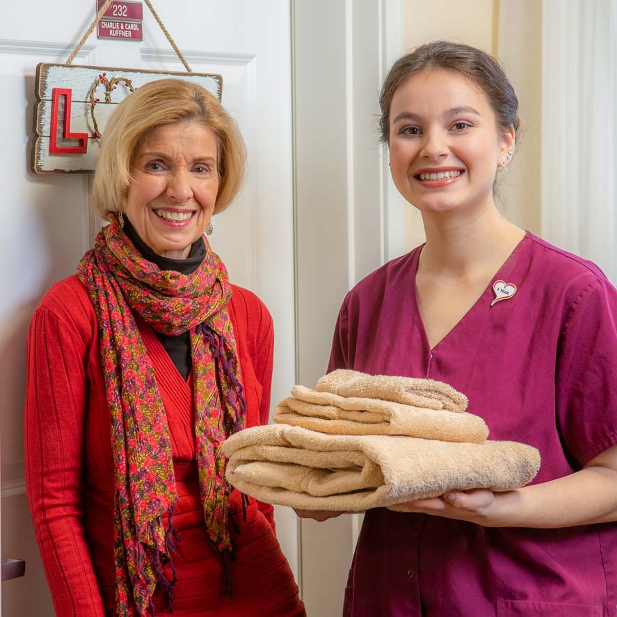 A team member delivering fresh linens to a resident at Desert Springs