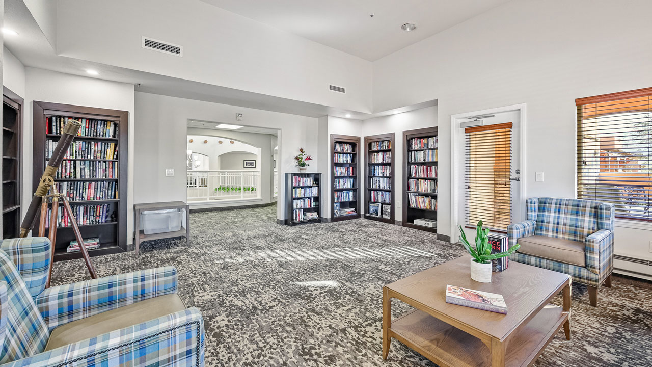 The library at Desert Springs with shelves of books and comfortable seating
